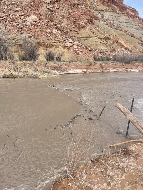 Warning, barbed wire fence across river